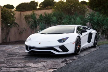 Белый Lamborghini Aventador S на фоне вечернего сада