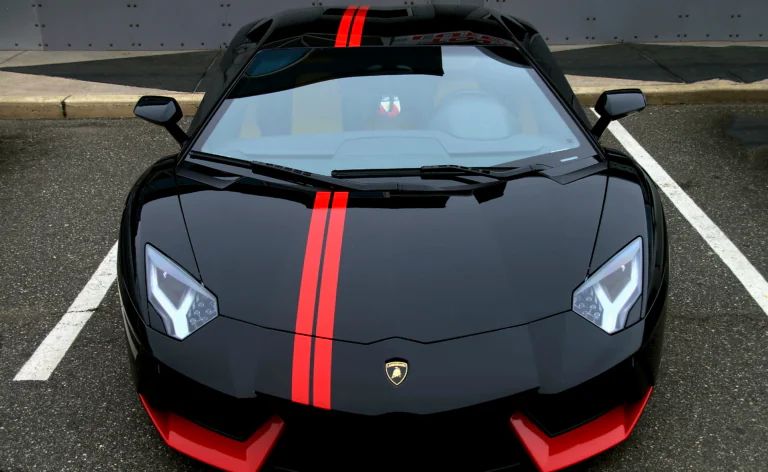 Черный Lamborghini Aventador с красными полосами на парковке