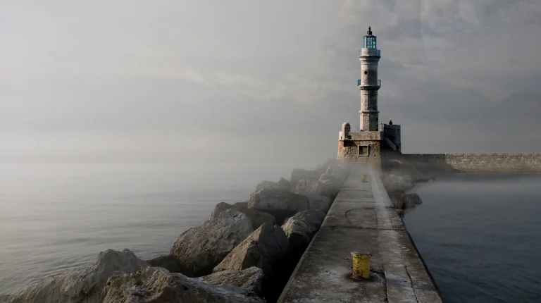An old lighthouse in the foggy harbor of Chania on the island of Crete