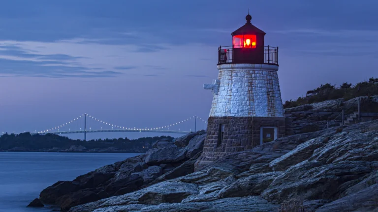 Castle Hill Lighthouse at dusk, with the Cloud-Newport Bridge in the background, in the United States