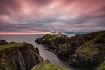 The Fana Head Lighthouse against the backdrop of a pink sunset in Ireland