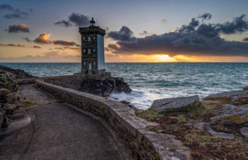 The Kergüen Lighthouse against the backdrop of a golden sunset in Brittany