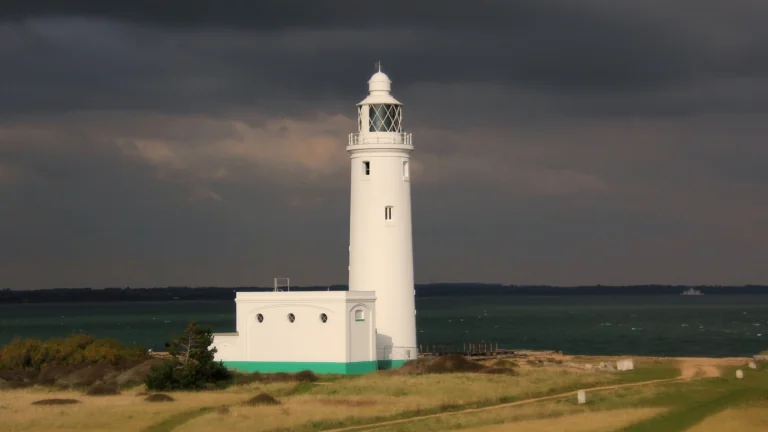 The snow-white Hurst Point Lighthouse against a stormy sky in the United Kingdom
