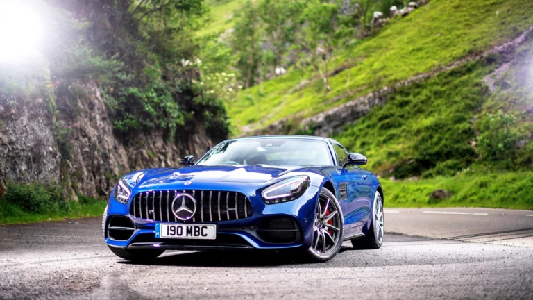 A blue Mercedes-AMG GT on a winding mountain road