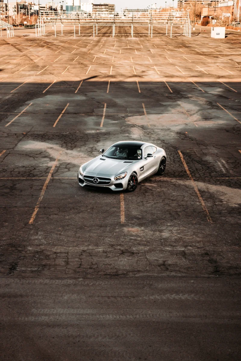 Серебристый Mercedes-Benz AMG GT на пустой асфальтированной парковке