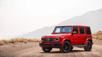 Красный Mercedes-Benz G-Class на пыльной пустынной дороге
