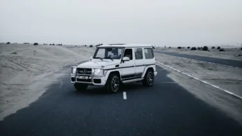 A white Mercedes-Benz G-Class SUV on a deserted road in the UAE