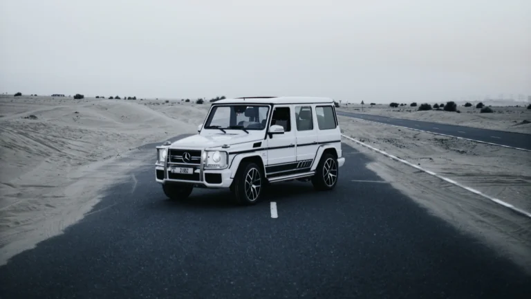 A white Mercedes-Benz G-Class SUV on a deserted road in the UAE