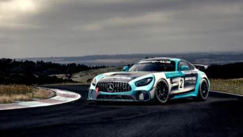 A Mercedes-AMG GT3 race car on a curve of the track under a cloudy sky
