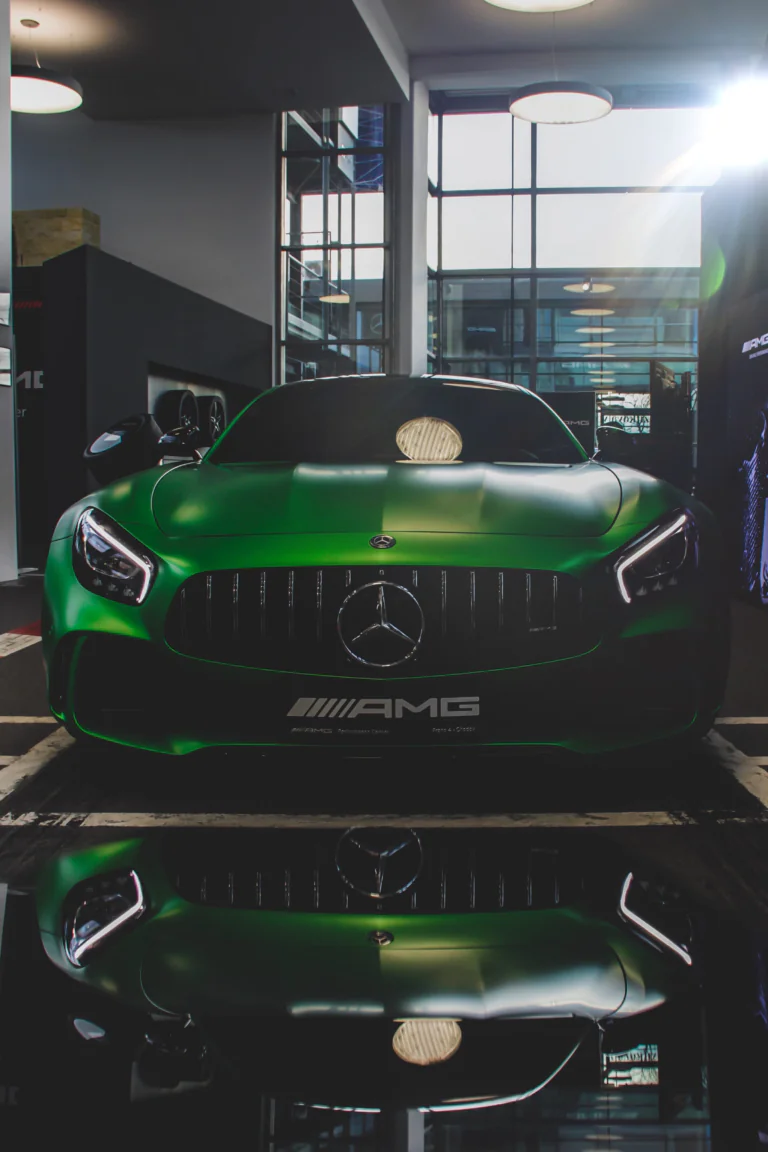 A green Mercedes-Benz AMG GT inside the showroom