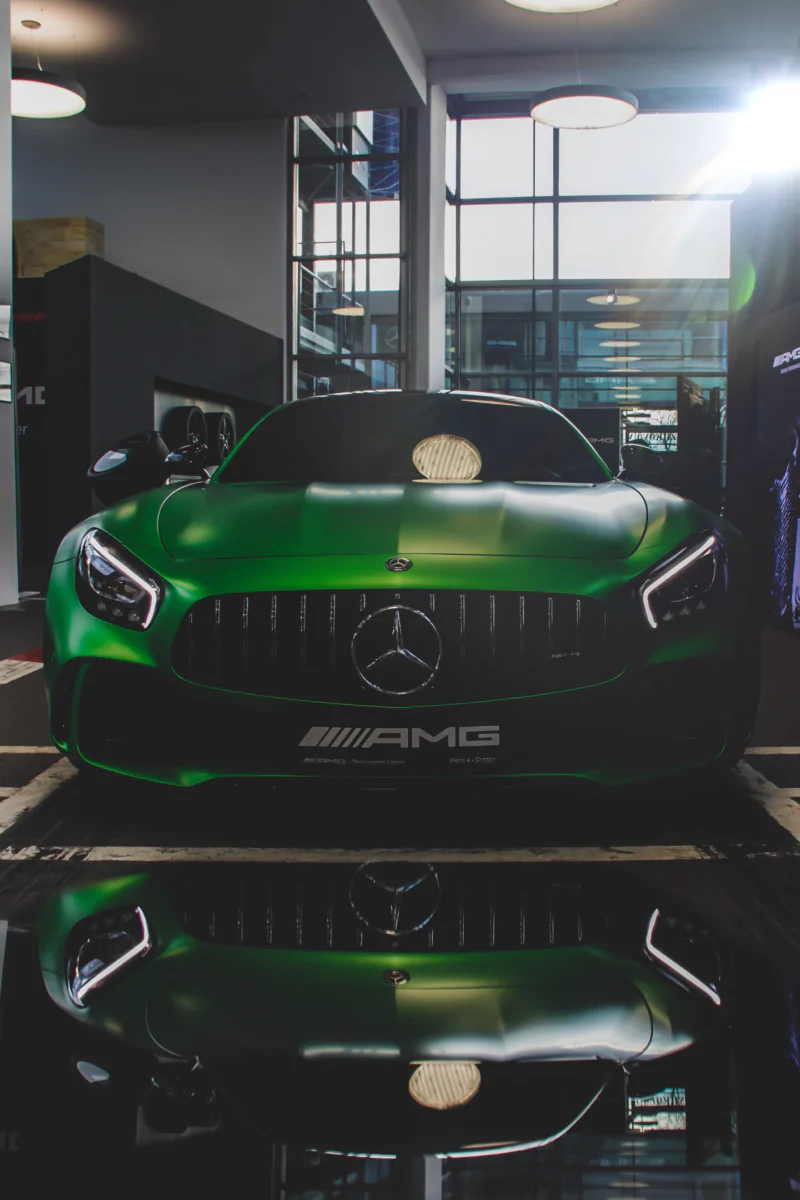 Зеленый Mercedes-Benz AMG GT в интерьере шоурума