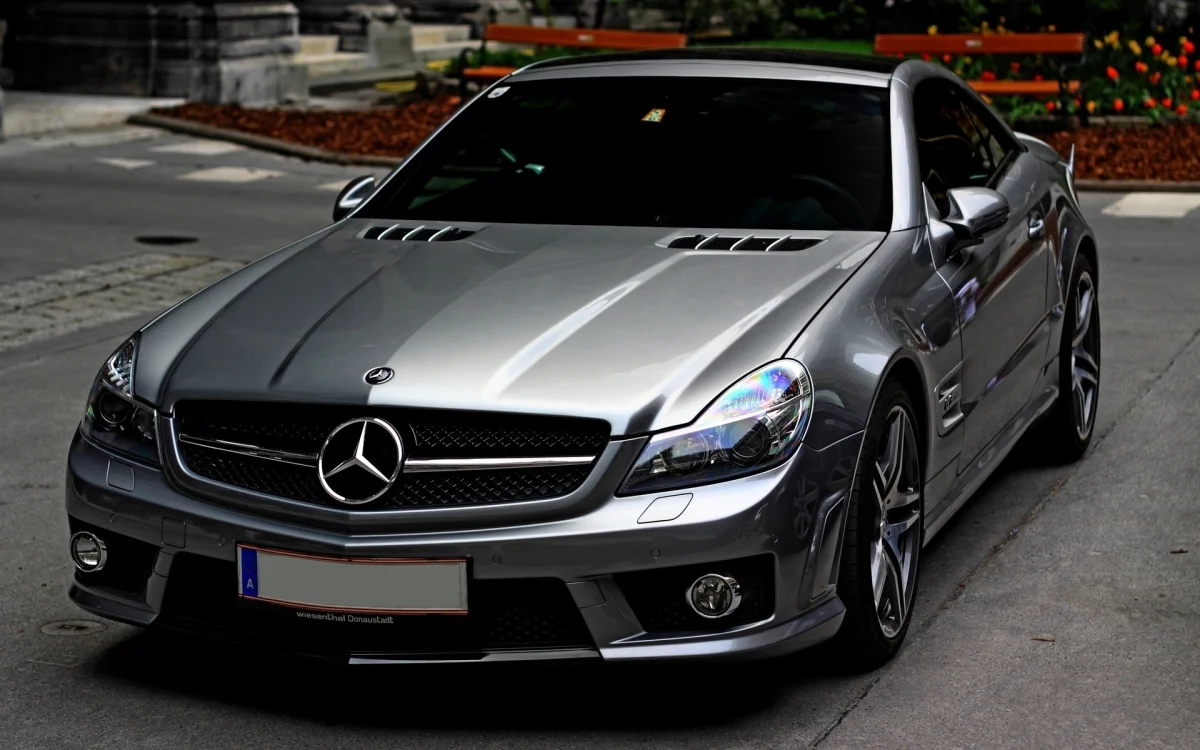 Сріблястий Mercedes-Benz SL-класу на міській вулиці
