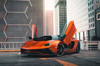 An orange Lamborghini Aventador among the city's skyscrapers
