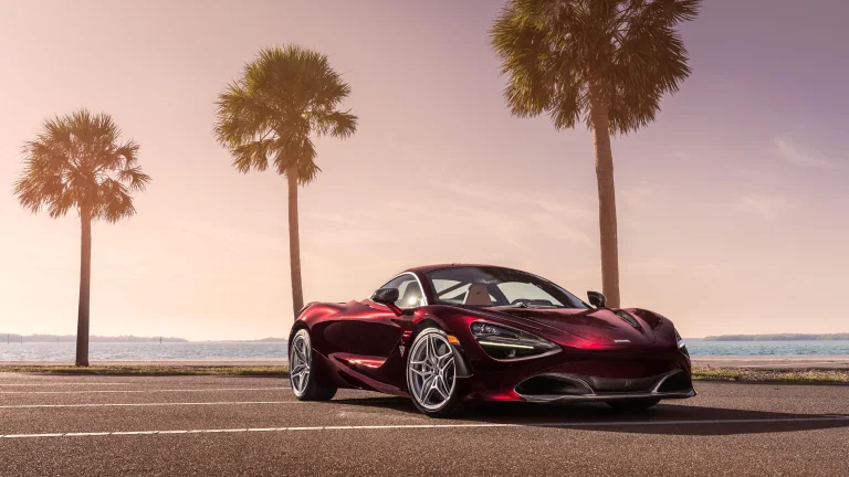 Бордовий McLaren 720S на тлі пальм у променях заходу сонця
