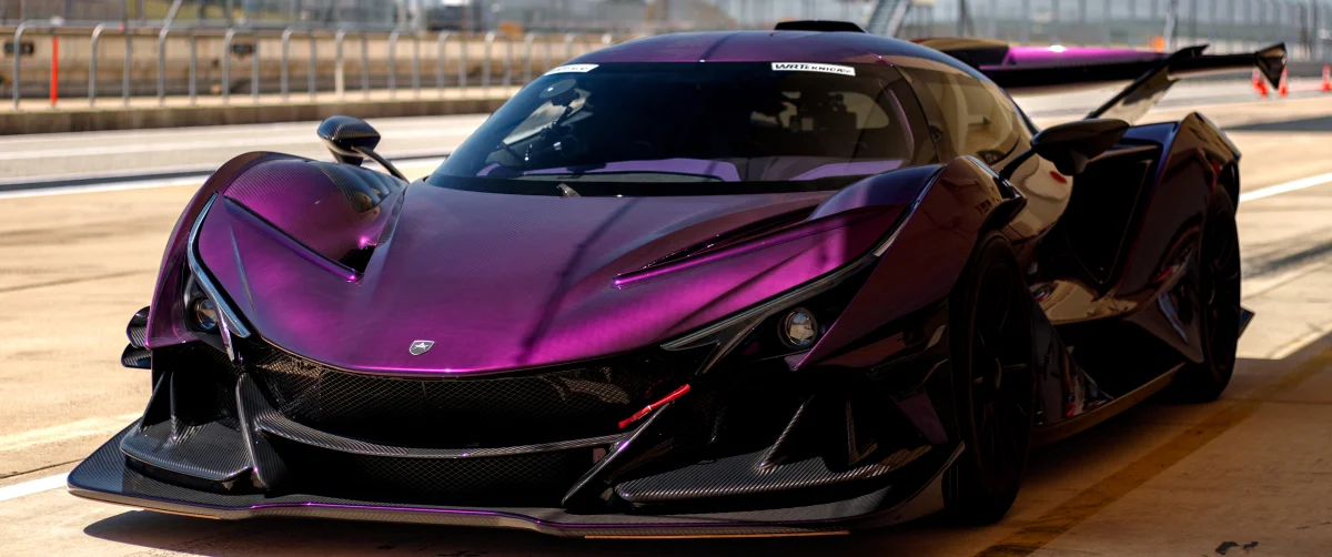 The purple Apollo Intensa Emozione hypercar on the race track