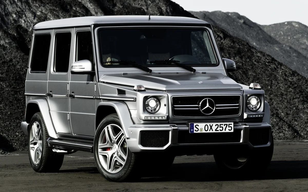 a silver mercedes-benz g-class against a rocky landscape, mercedes-benz g-class, cars, automobiles, discs, wheels, headlights, mercedes-benz, mountains, peaks, hills, suvs, auto, vehicles