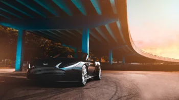 Черный Aston Martin DBS Volante под опорами эстакады