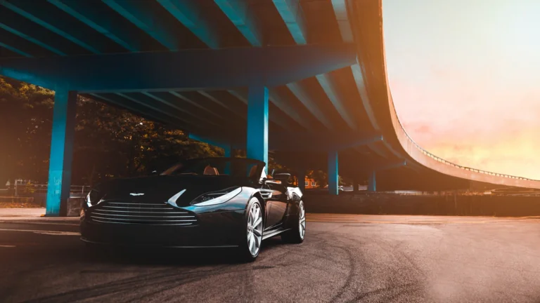 Черный Aston Martin DBS Volante под опорами эстакады