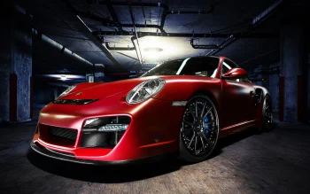 A red Porsche 911 in the dim light of the underground parking garage