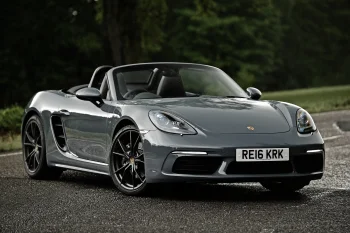 Серый Porsche 718 Boxster на лесной дороге