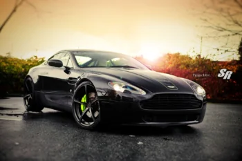 An Aston Martin V8 Vantage against the backdrop of a sunset sky
