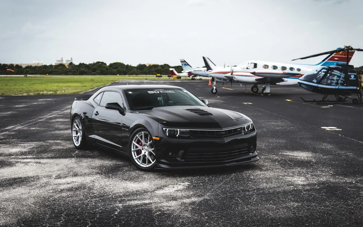 Чорний Chevrolet Camaro на аеродромі