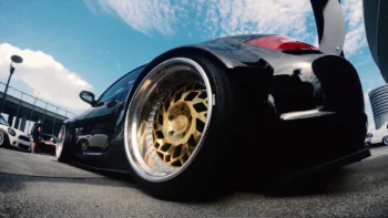 A black Porsche Cayman with gold rims