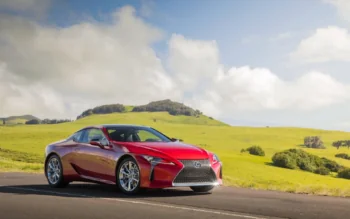 Красный Lexus LC на фоне зеленых холмов