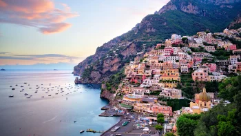 The colorful houses of Positano on a hillside along the Italian coast, bathed in the glow of the sunset
