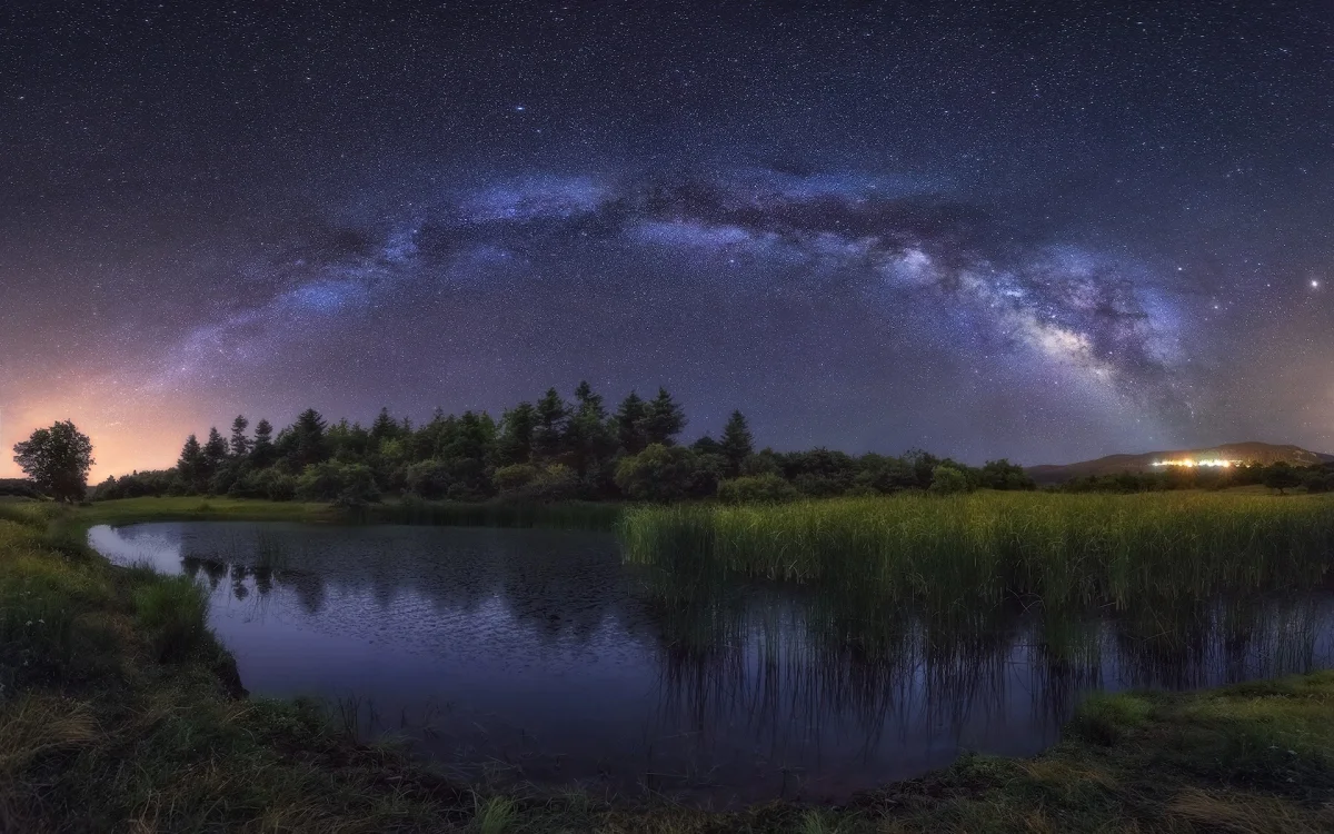 The Milky Way over a quiet forest lake