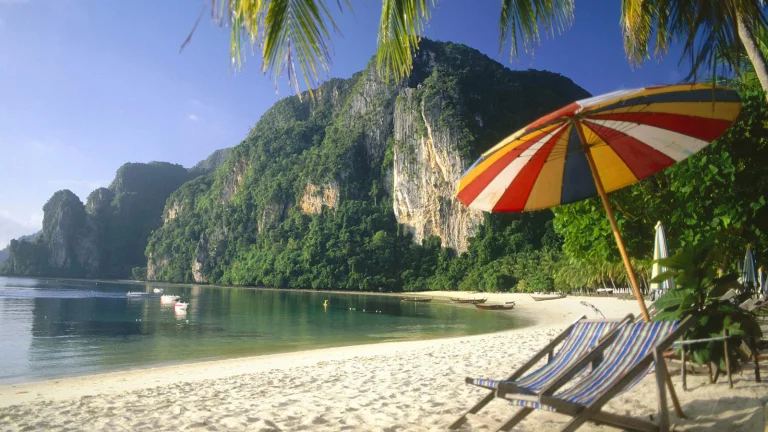 beach chairs against the backdrop of the rocky shore of phi phi island in thailand, phi phi island, thailand, beach chairs, beaches, coasts, boats, motorboats, speedboats, cliffs, islands, lagoons, landscapes, mountains, peaks, hills, palm trees, sand, sands, sea, umbrellas, nature, world