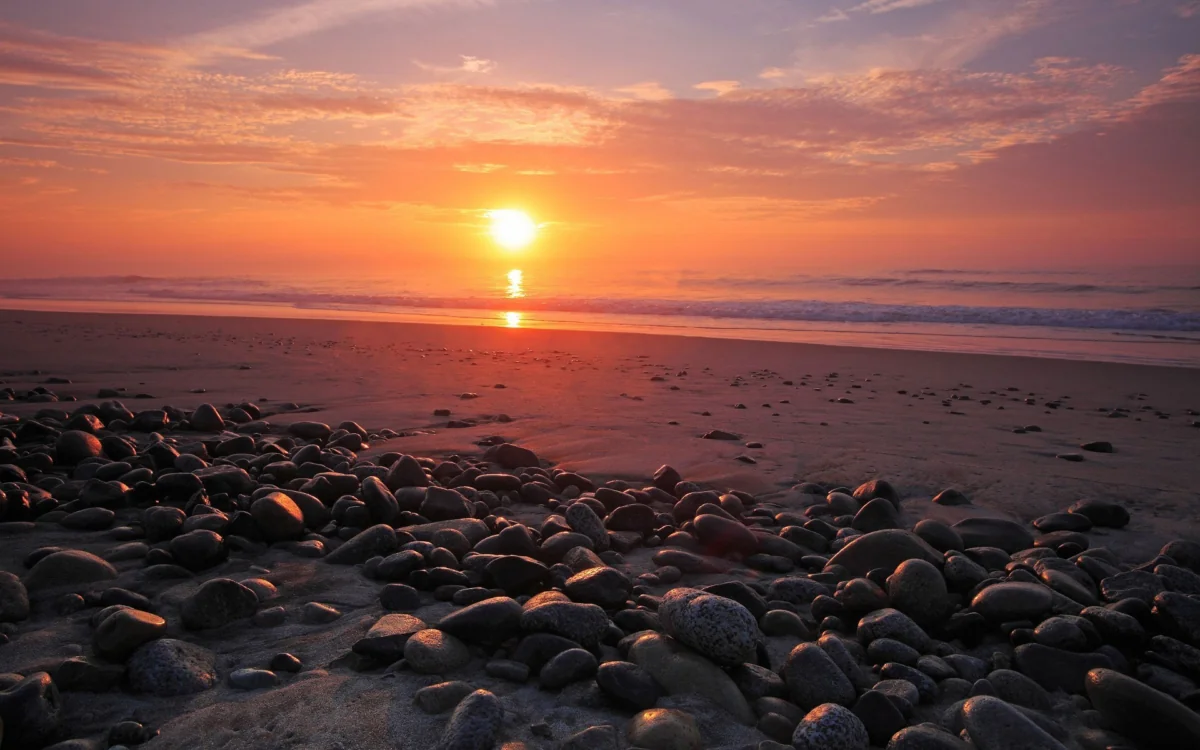 A golden sunset over the rocky ocean shore