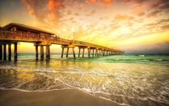 A wooden pier against the backdrop of a golden sunset sky
