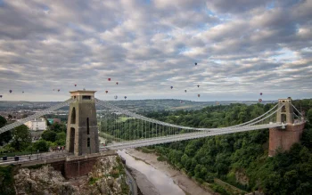the clifton suspension bridge in bristol, with hot air balloons against the sky, avon, england, balloons, bridges, clouds, engineering marvel, engineering structures, forest, forests, landscapes, mountains, peaks, hills, rivers, canals, streams, sky, united kingdom, architecture, world