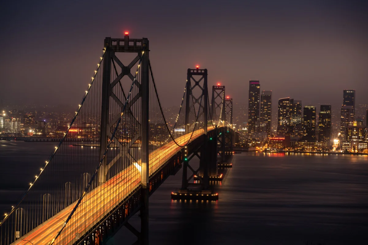 The lights of the Bay Bridge in San Francisco against the backdrop of the city at night