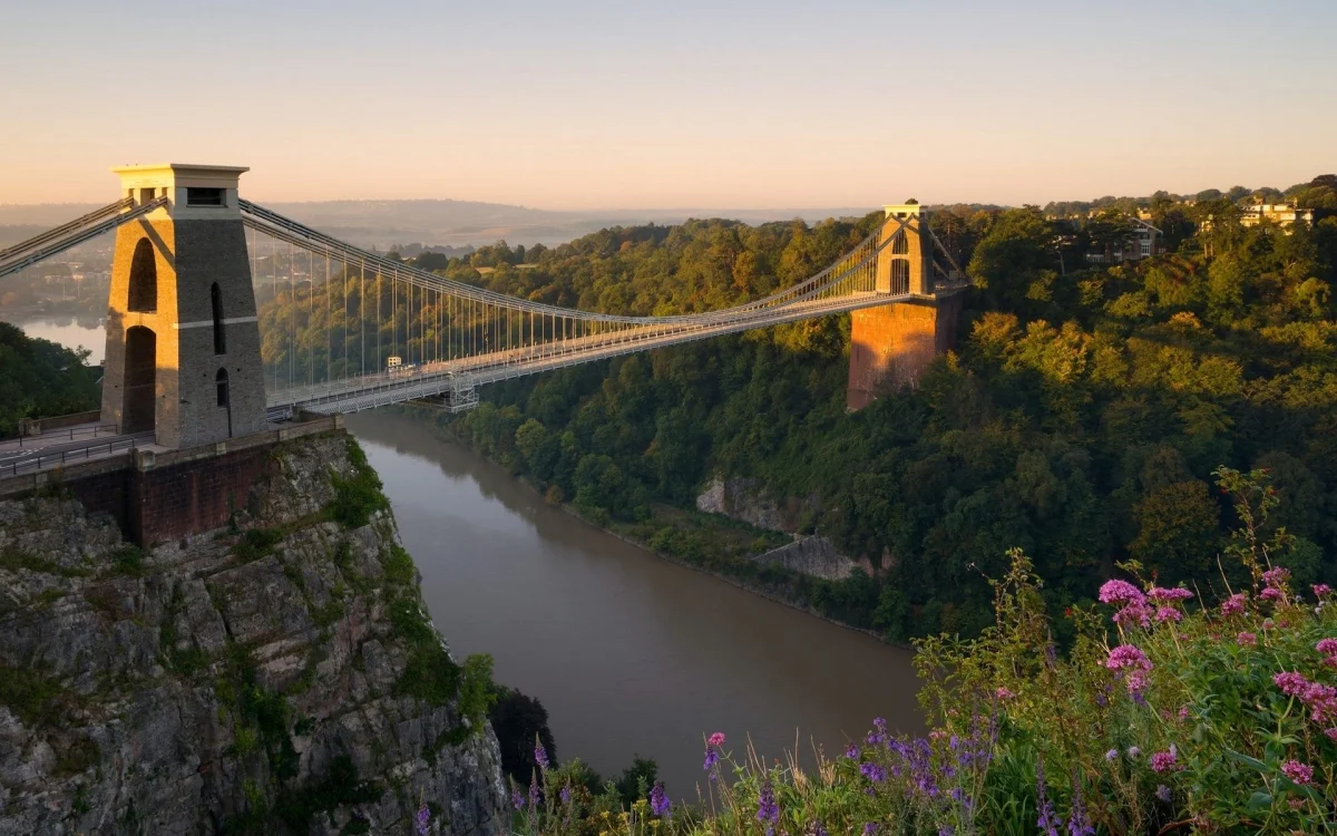 the clifton suspension bridge in the united kingdom at sunset, clifton suspension bridge, england, bridges, cliffs, engineering marvel, engineering structures, flowers, forest, forests, landscapes, rivers, canals, streams, sunsets, sunset, united kingdom, architecture, world