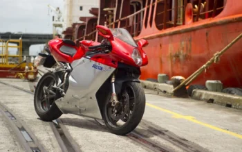 A red MV Agusta F4 against the backdrop of a cargo ship in the harbor