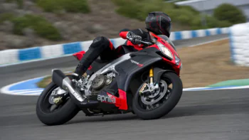 An Aprilia RSV4 sport bike on a sharp turn on a race track