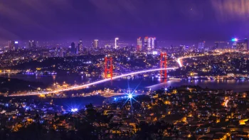 the lights of the bosphorus bridge in istanbul against a purple sky, turkey, bridges, cities, city, cityscape, cityscapes, night lights, lights, streetlights, street lamps, lighting, night, rivers, canals, streams, skyscrapers, the city at night, architecture, world