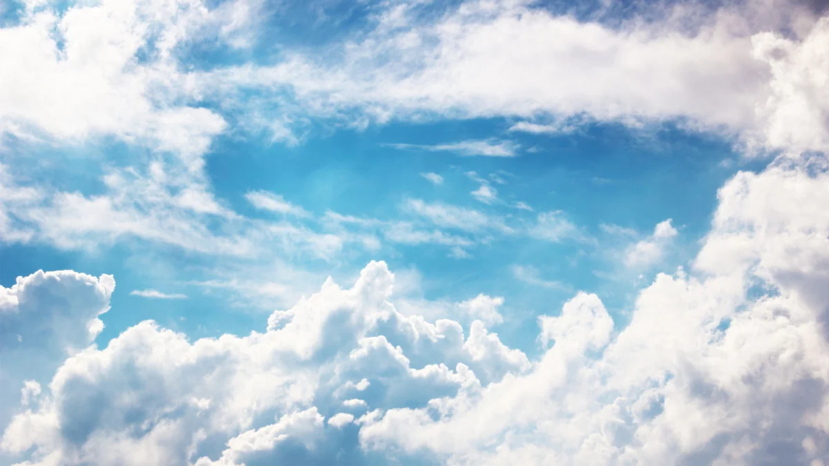 Snow-white cumulus clouds in a bright blue sky