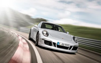 Сріблястий Porsche 911 на швидкісному повороті гоночної траси