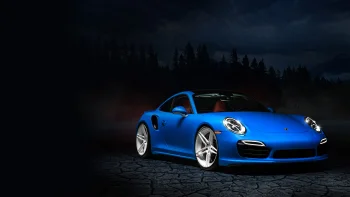A blue Porsche 911 against the backdrop of a forest at night