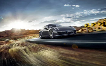 Сірий Porsche 911 на звивистій гірській дорозі