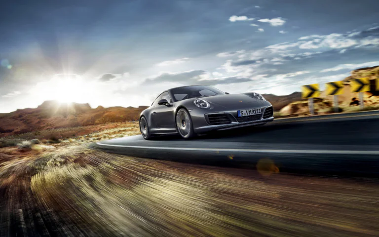 Серый Porsche 911 на извилистой горной дороге