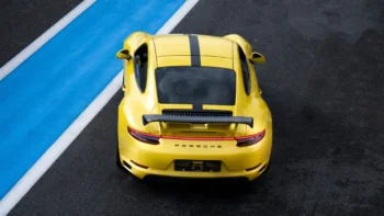A bright yellow Porsche 911 on the race track