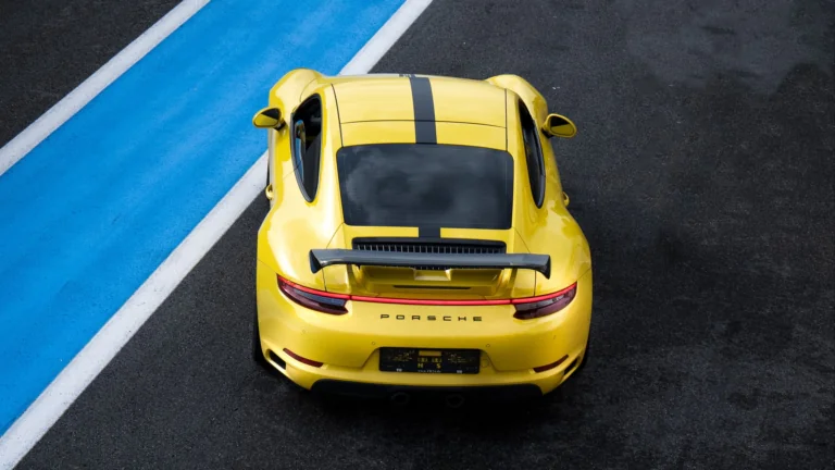 A bright yellow Porsche 911 on the race track