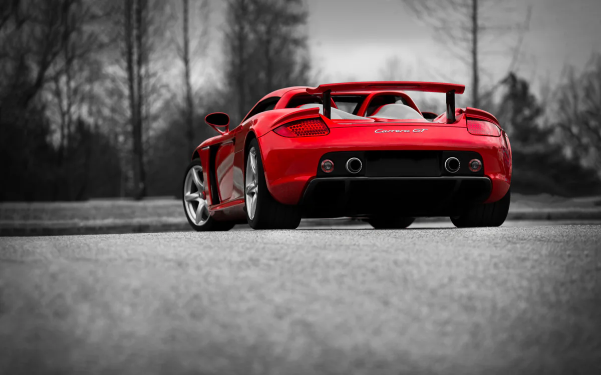 Красный Porsche Carrera GT на фоне осеннего парка