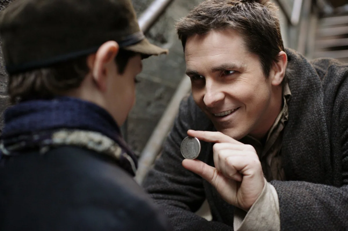 Christian Bale performs a coin trick