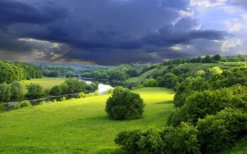 green meadows and a winding river beneath a stormy sky, clouds, forest, forests, herb, herbs, lawns, landscapes, mountains, peaks, hills, rivers, canals, streams, sky, trees, nature, world