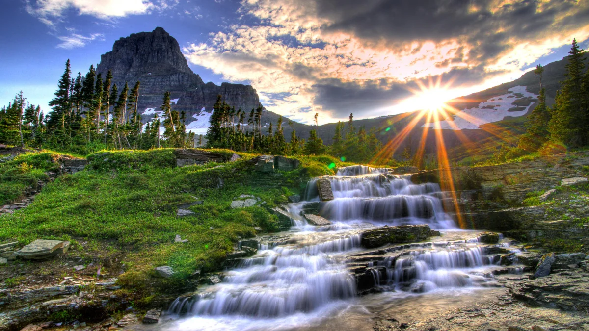 Sunset over a cascading waterfall in Glacier National Park
